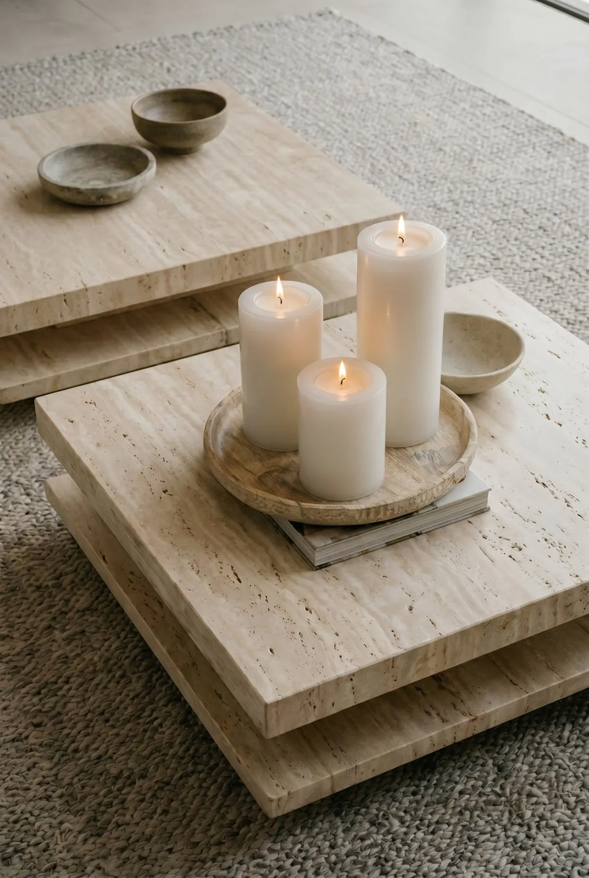 Three candles on stacked travertine tables